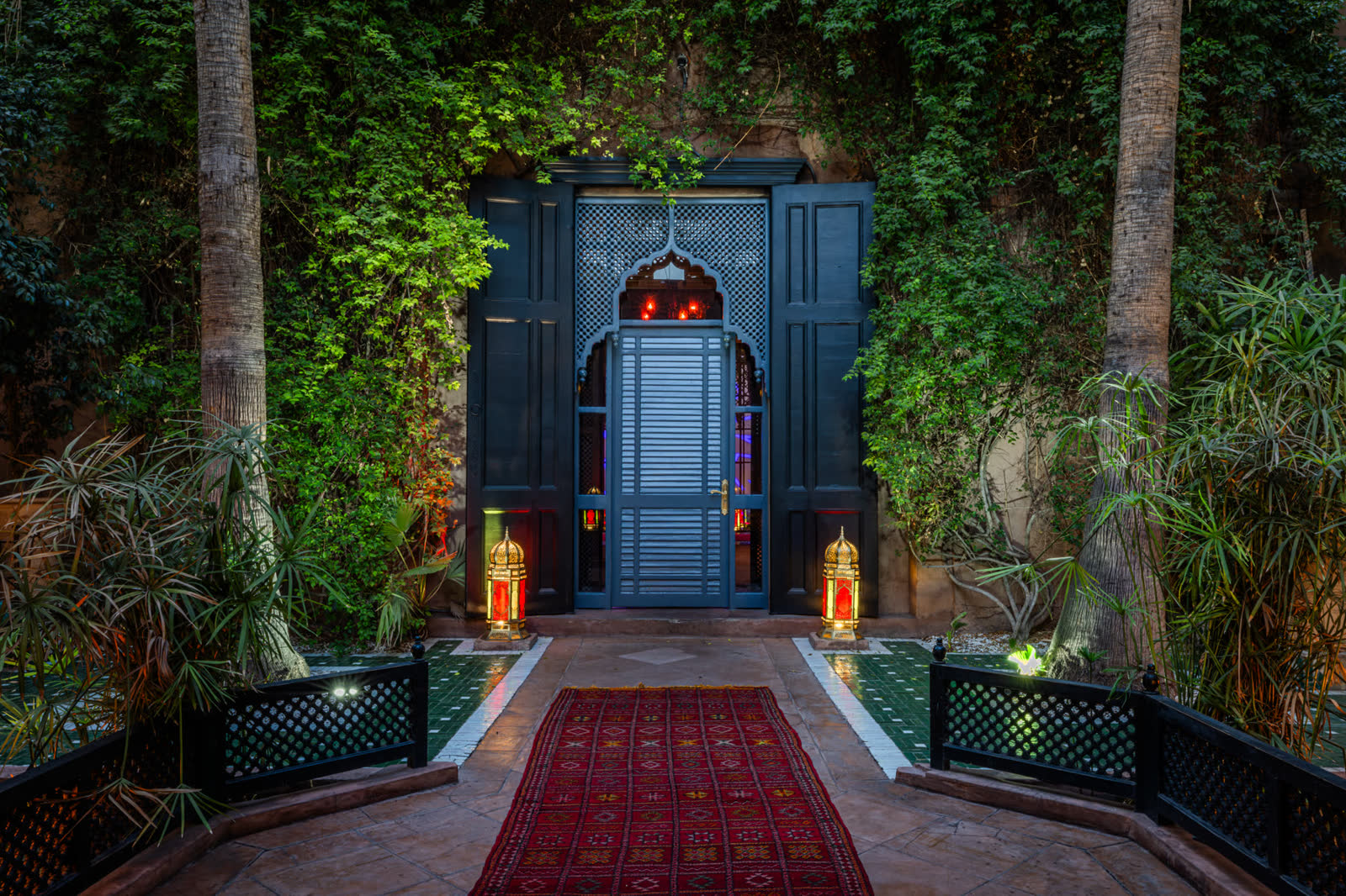 Entrée du palais entre les palmiers, tapis rouge